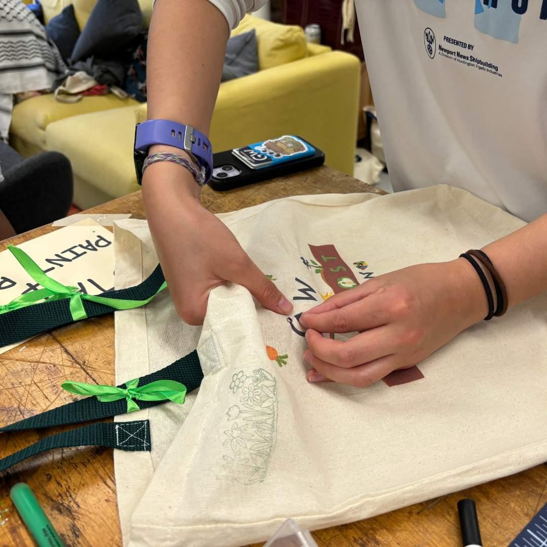 A student decorates a tote bag at an earth month event